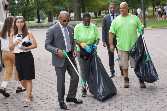 A photo of Mayor Eric Adams personally demonstrating how to dispose of yard scraps.